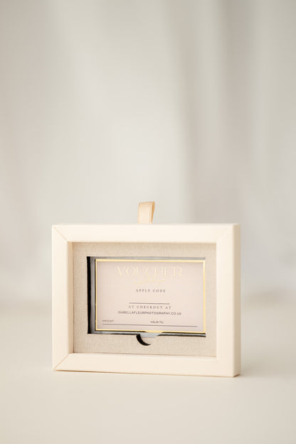 Gift voucher in a decorative box on a textured white surface