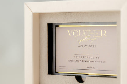 Gift voucher in a decorative box with gold text on a gray background