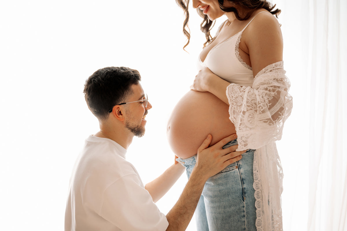Maternity photoshoot with couple kissing baby bump